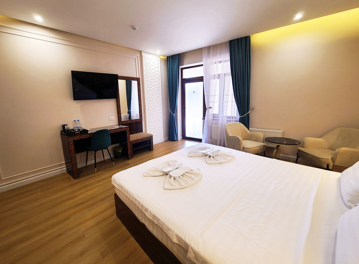 Inviting superior double room in the hotel with a double bed, desk, and TV